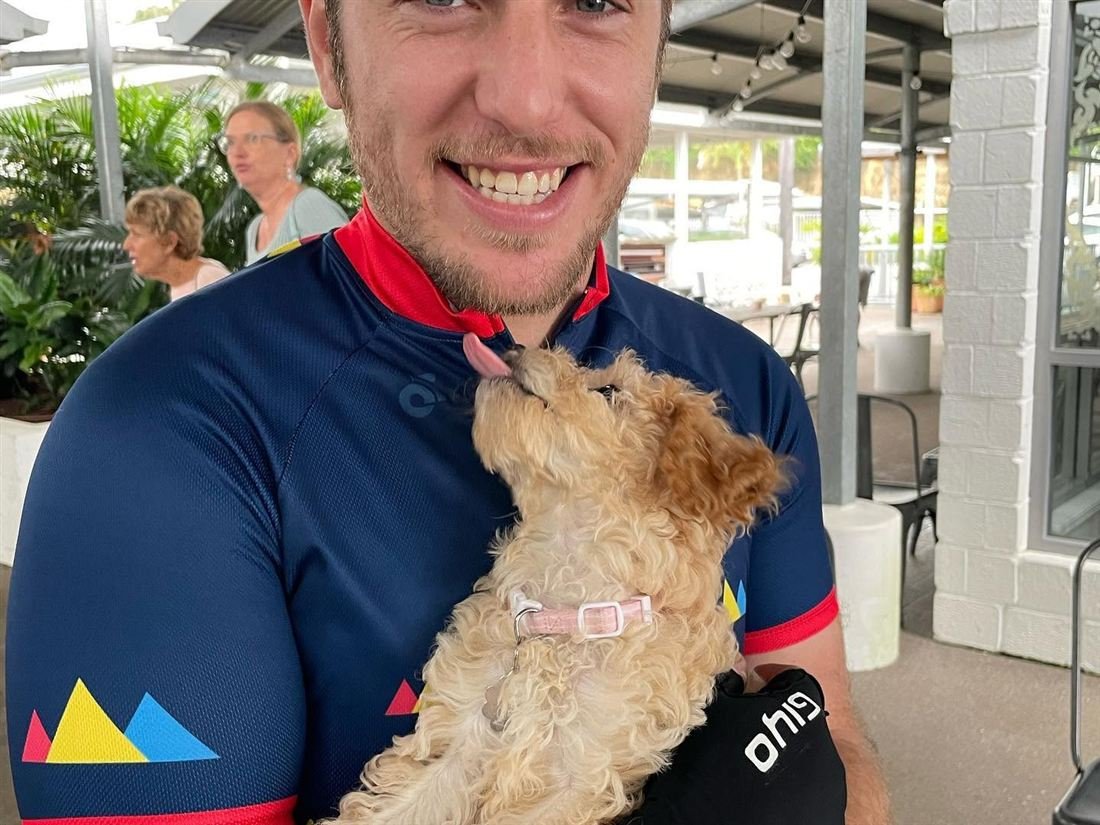 Robert Heideman in cycling kit with a puppy